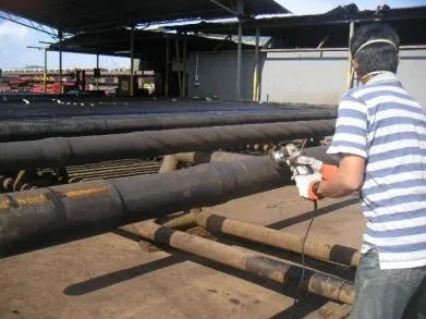 Technician inspecting drill pipe on a pipe rack